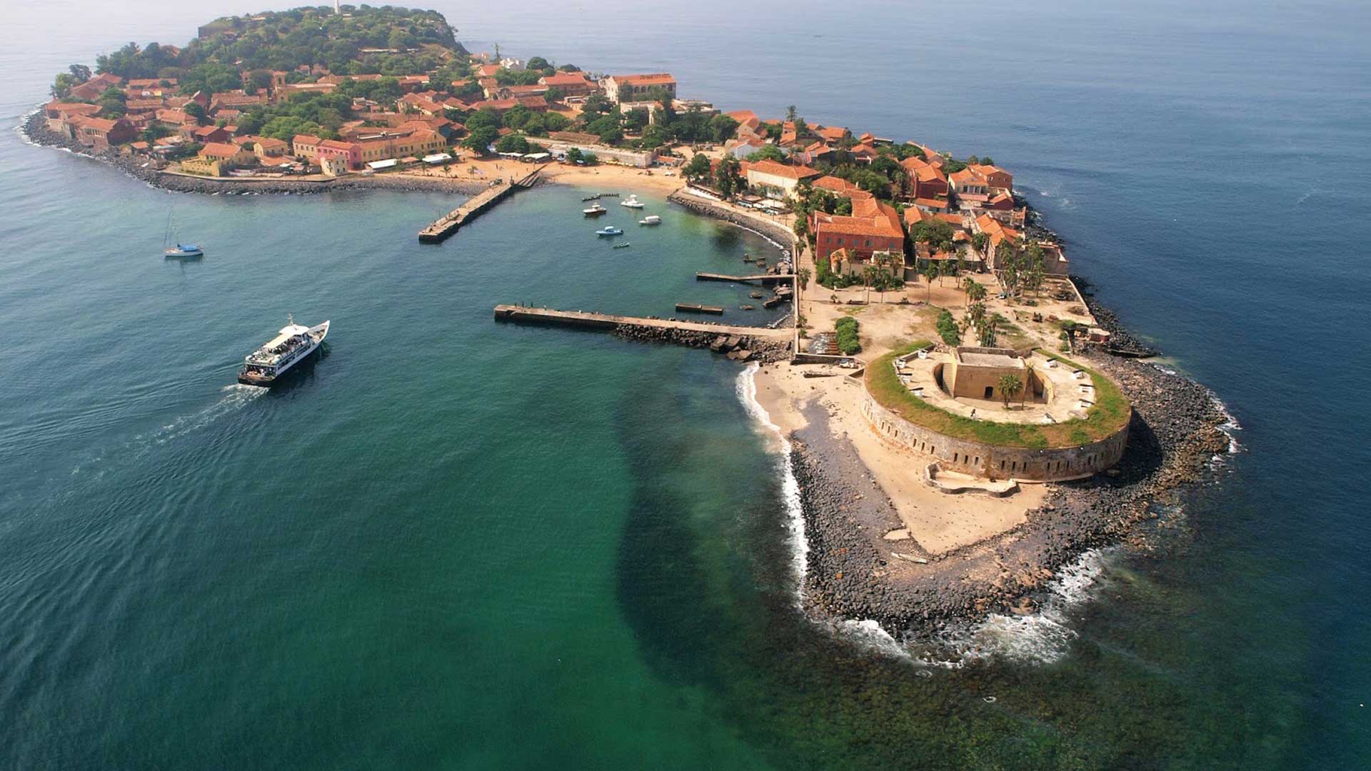 Charmante petite île au large de Dakar, avec ses maisons pastel et ses innombrables restaurants, devenue un lieu touristique incontournable du Sénégal de par son rôle durant la traite des esclaves.