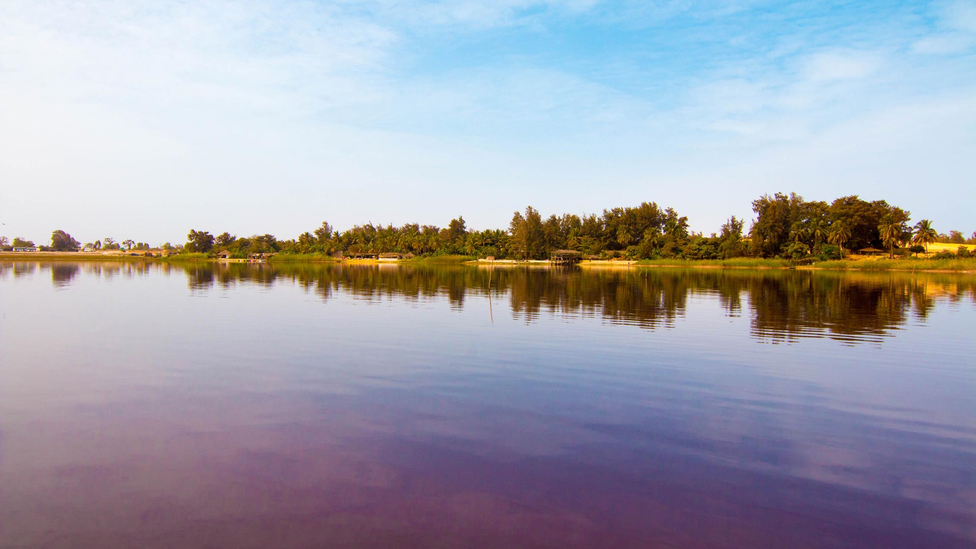 Sur 5 km de long pour 800 m de large, séparé de l’océan par un interminable cordon dunaire planté de filaos, le Lac Rose ou Lac Retba, est l’une des principales attractions touristiques du Sénégal.